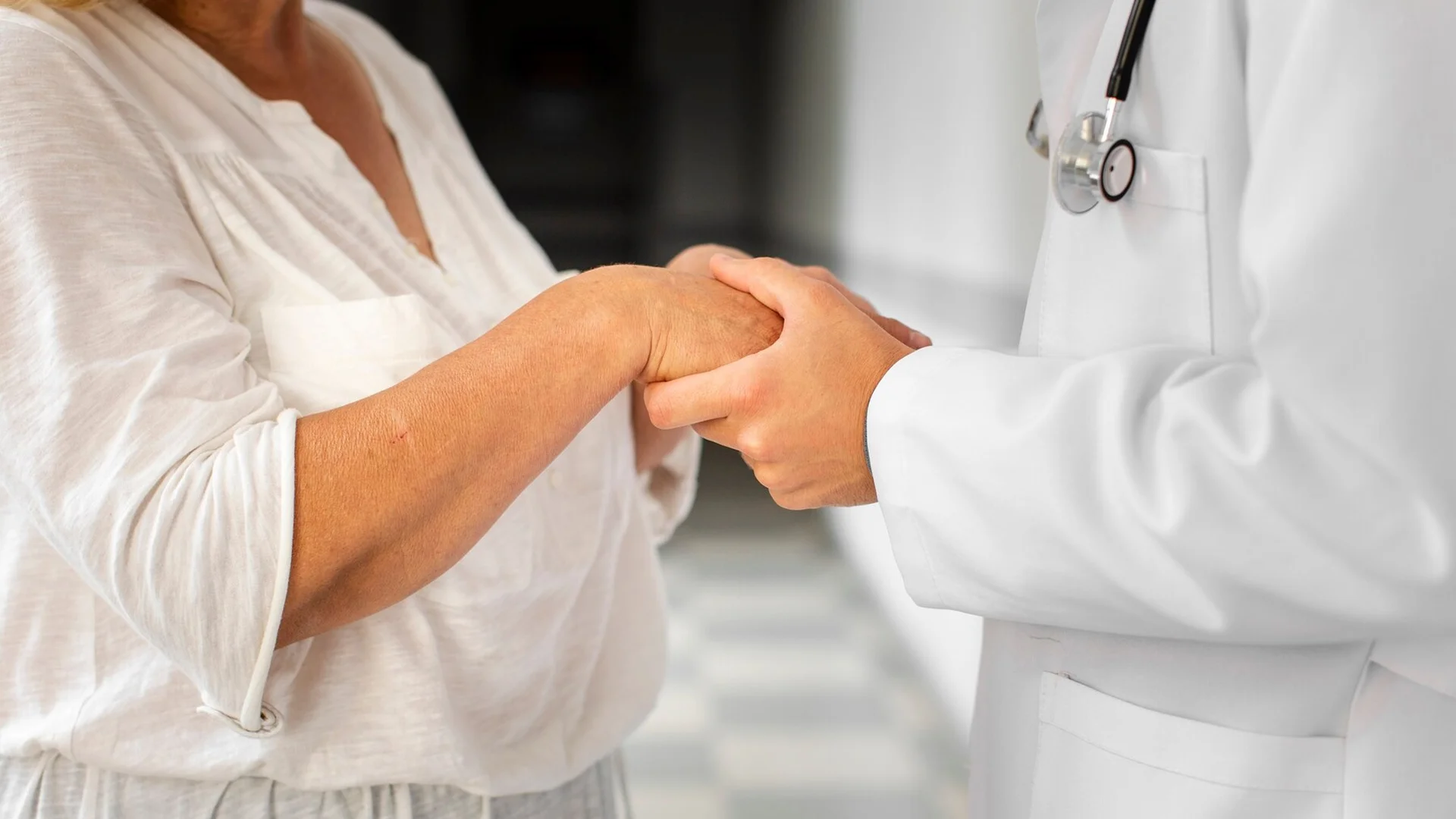 Provider and patient holding hands symbolizing the support and partnership with the GUIDE program.