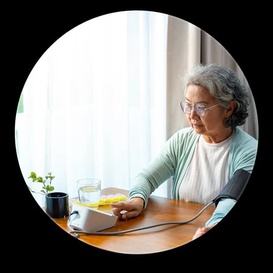 elderly woman using remote patient monitoring device