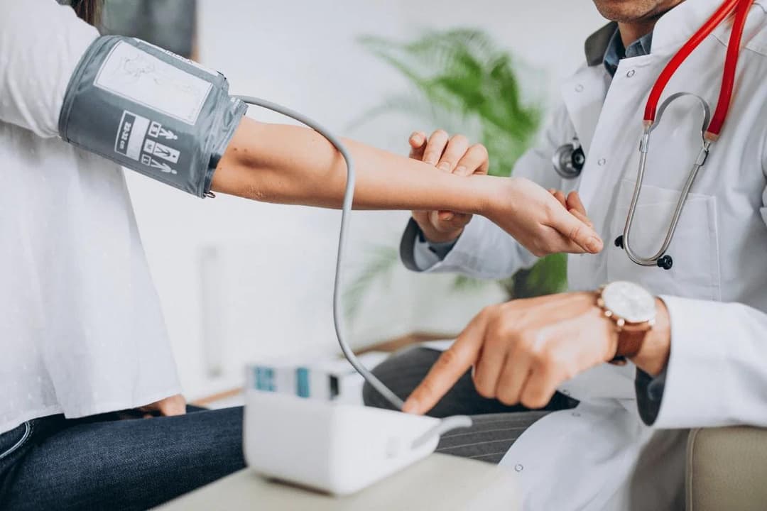 Doctor measuring patient's blood pressure with cuff.