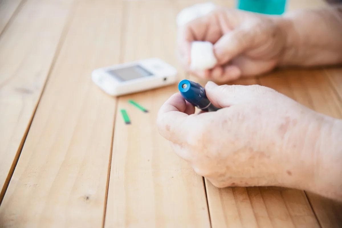 Close-up of hands holding a blood glucose testing device.