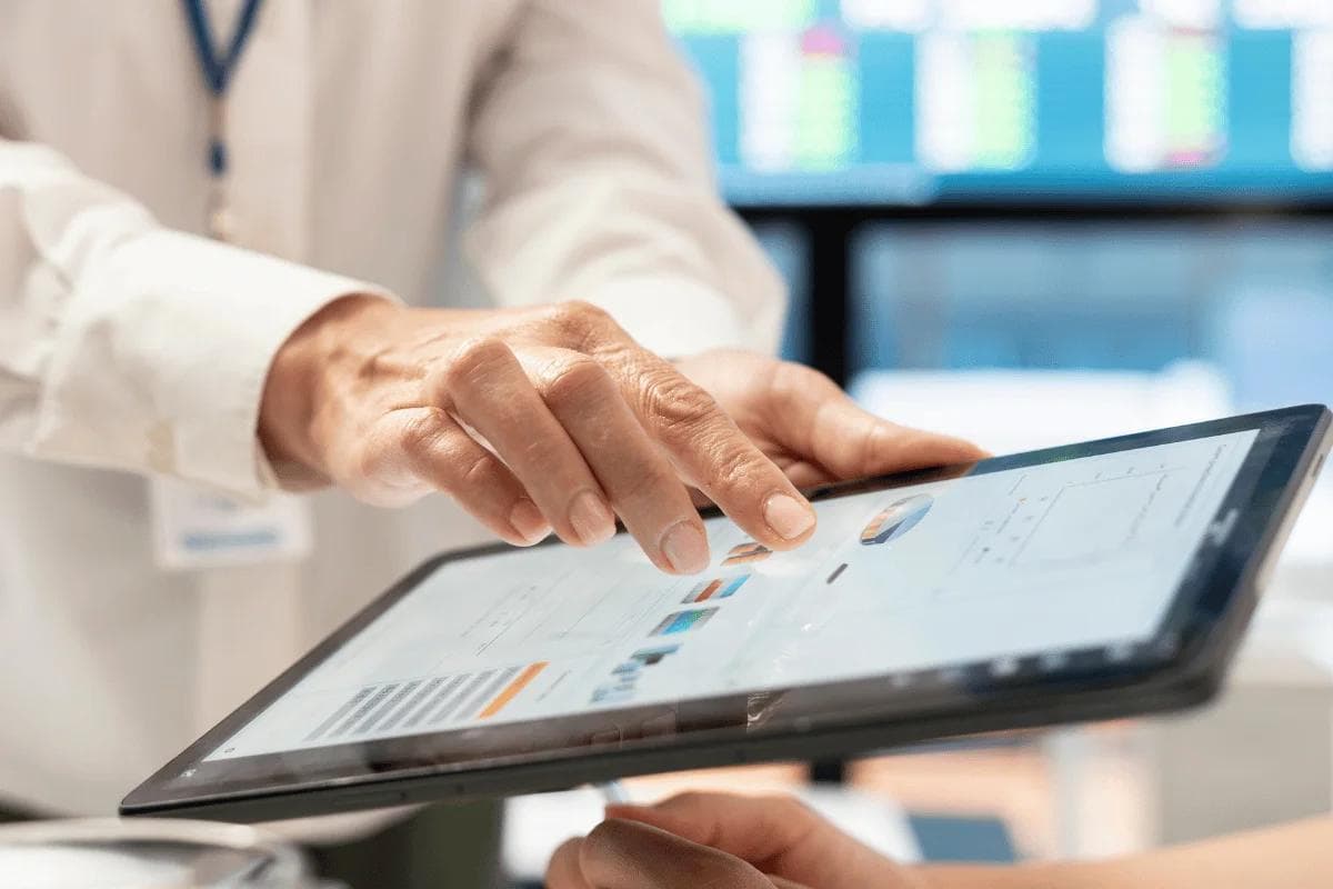 Business professional analyzing data on a digital tablet.