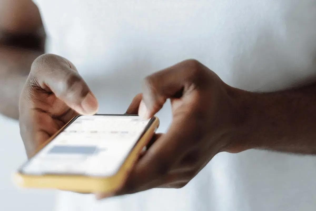Person texting on smartphone with focus on hands.