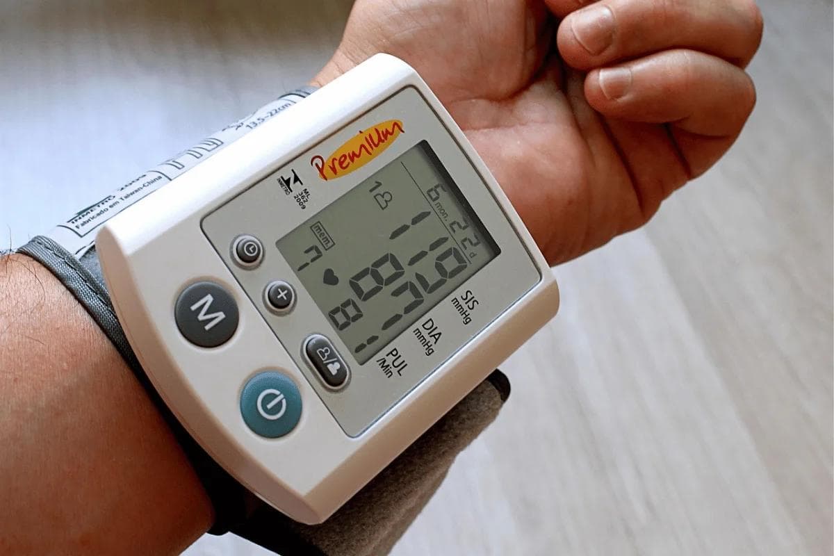 Person wearing a digital wrist blood pressure monitor.