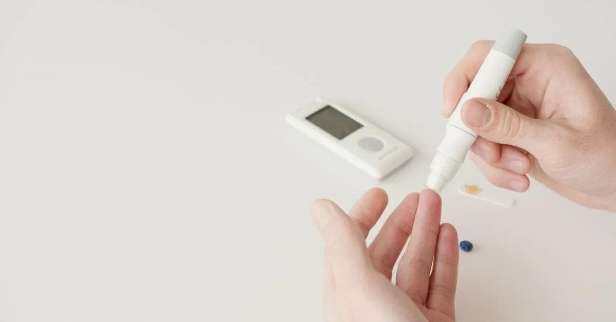 Hand holding glucose monitoring device with digital display showcasing future of connected health technology.