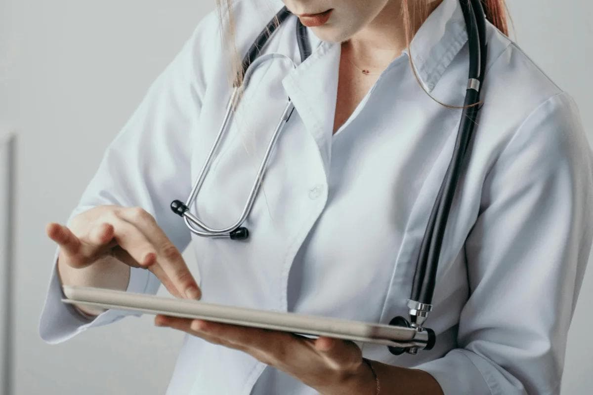 Doctor using tablet to review patient data and medical records.