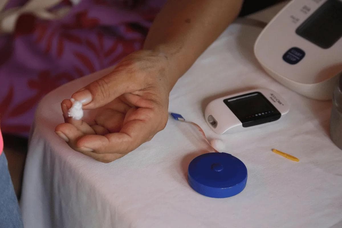 Person using a glucose meter for blood sugar testing at home.