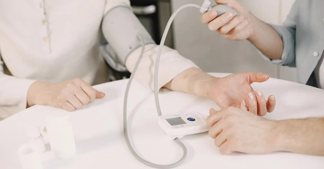 Healthcare provider taking blood pressure reading using digital monitor for FQHC remote patient monitoring program.