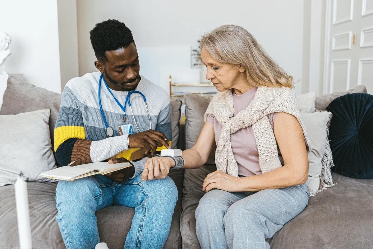 Healthcare professional checks an elderly woman’s oxygen levels at home, highlighting compassionate senior care services.