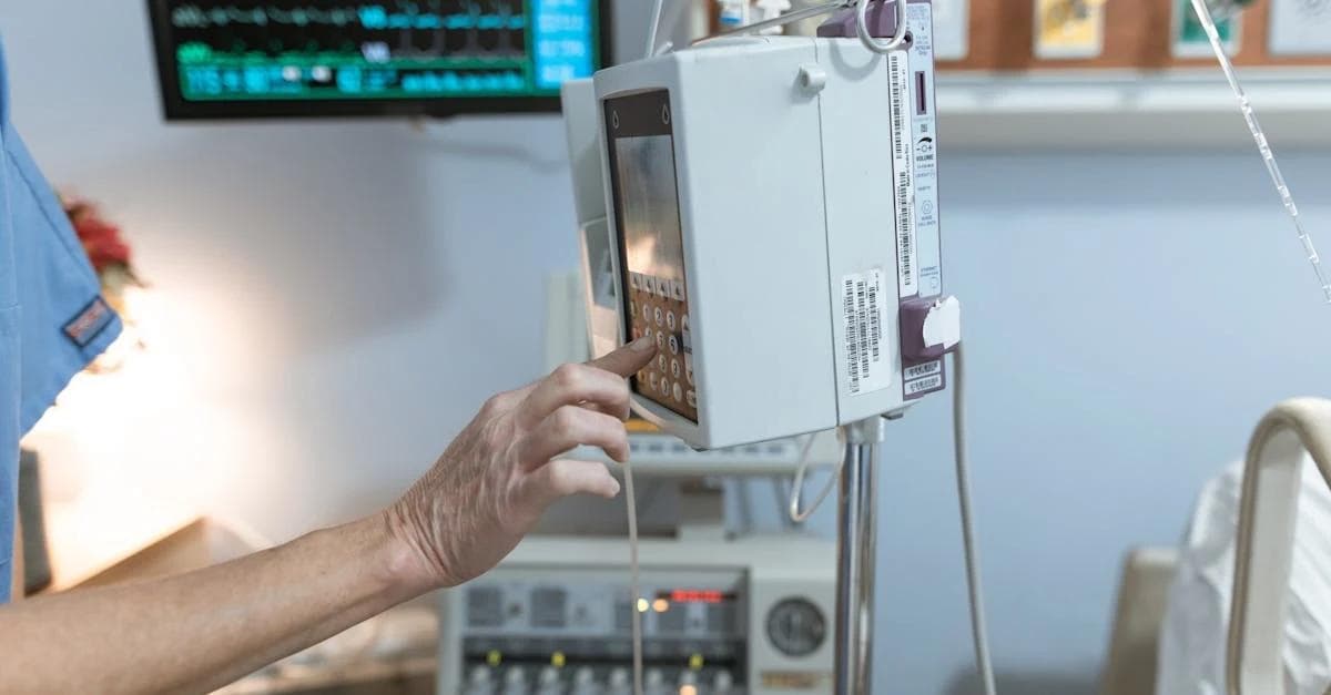 A healthcare professional adjusts a touchscreen on medical equipment in a hospital room.