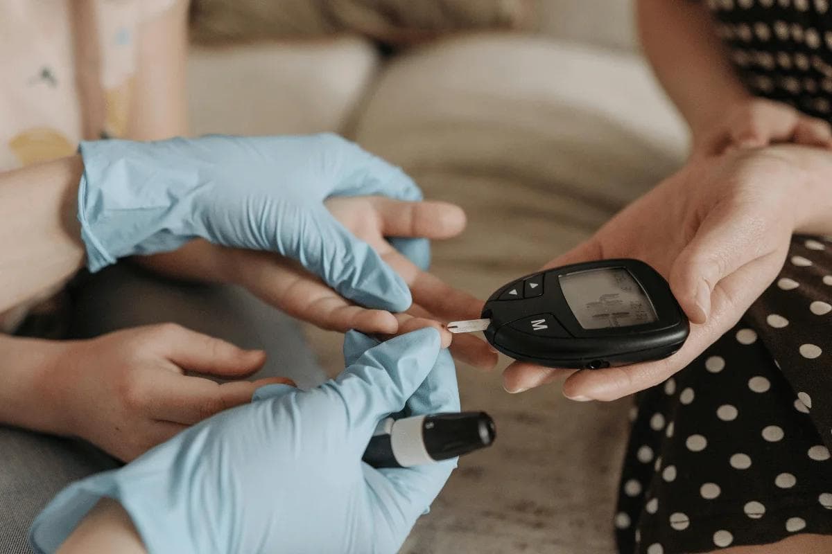 Healthcare worker using a glucometer to check blood sugar.